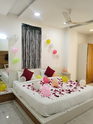 A room decorated for a celebration with balloons and petals
